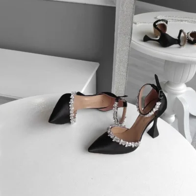 کفش مجلسی زنانه پاشنهبلند با پاشنه شفاف ۱۱ سانتیمتری و بند مچ، از جنس ساتن مشکی با نگینهای تزئینی در دو خط. - 6742